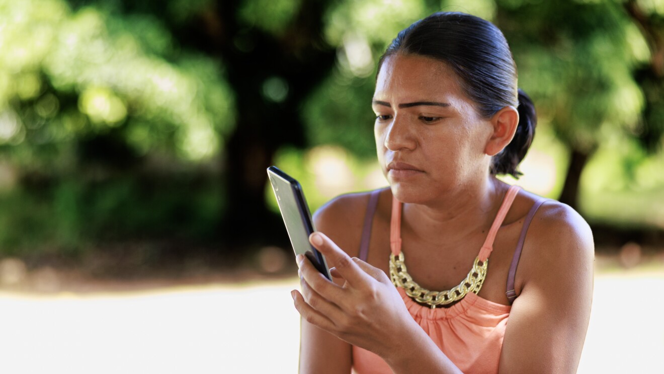 Mujer mirando un teléfono móvil. 