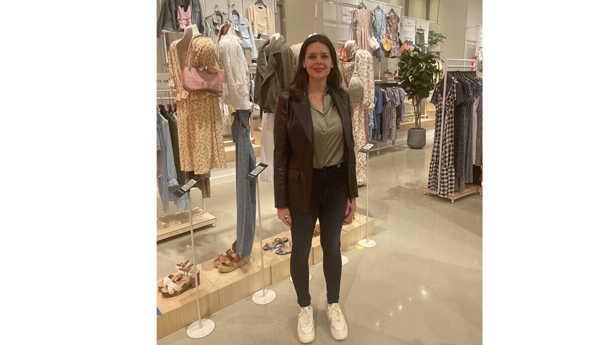 An image of a woman smiling for a photo while standing in an Amazon Style store.