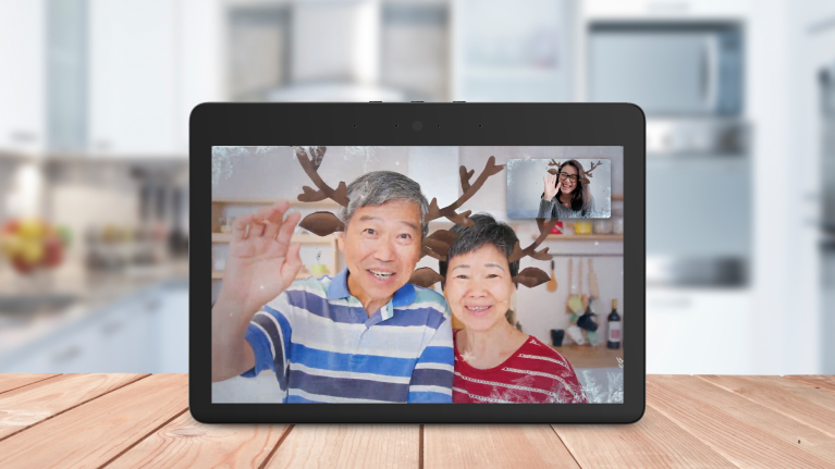An image of an Echo Show call showing three people waving with the reindeer filter.