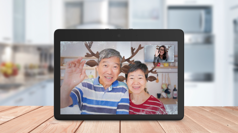 An image of an Echo Show call showing three people waving with the reindeer filter. 