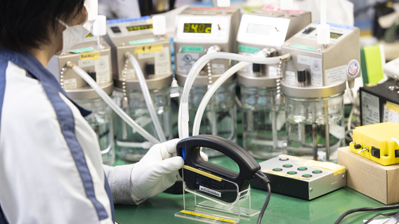 数本のホースにつなげられた器具を持つ作業員