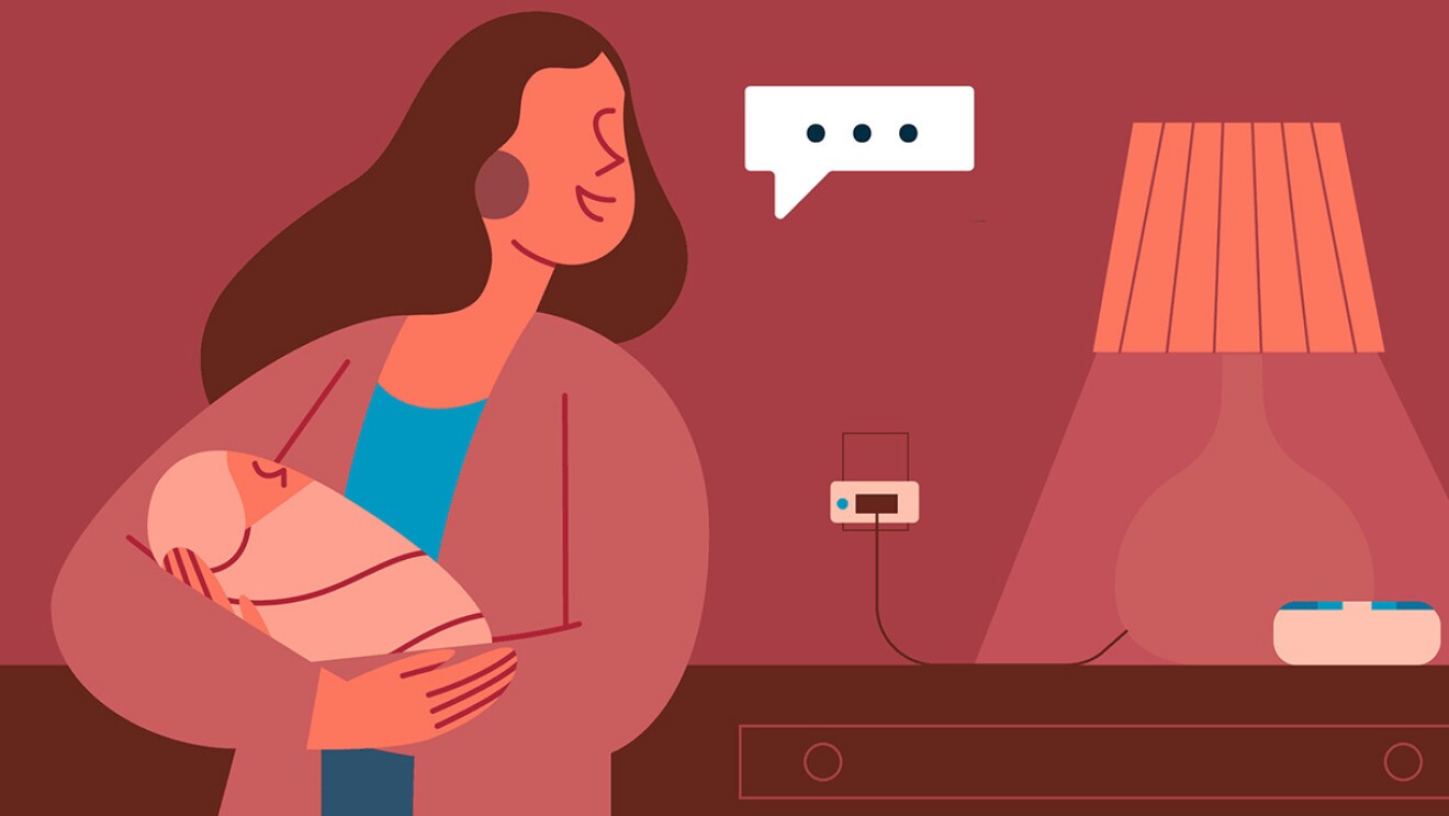 图为一名女子抱着婴儿对她身后抽屉上的亚马逊Echo设备说话。在Echo旁边是一盏插在墙上的灯。