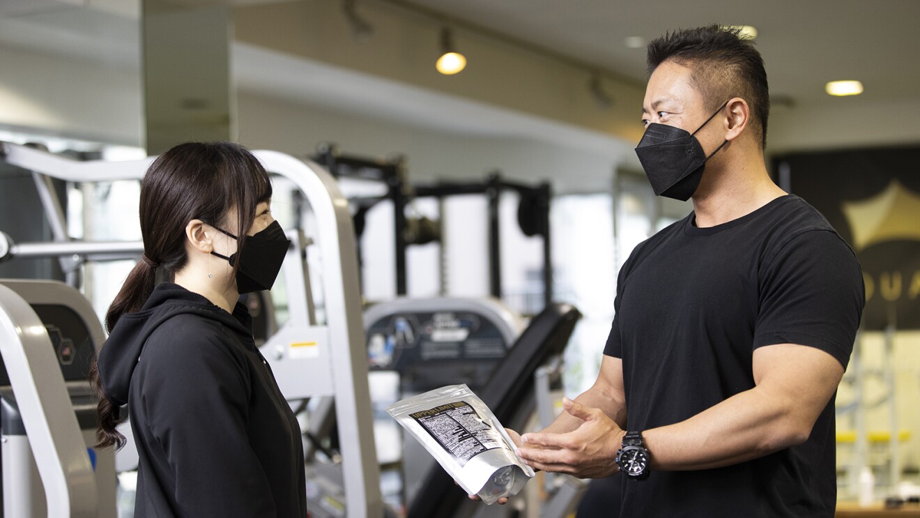 ジムで商品を持って話す大谷さん達