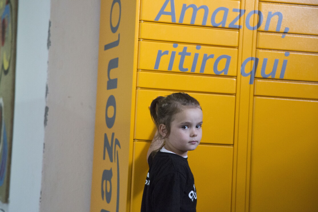 Una bambina davanti all'Amazon Locker Geremia nella Biblioteca di Scampia