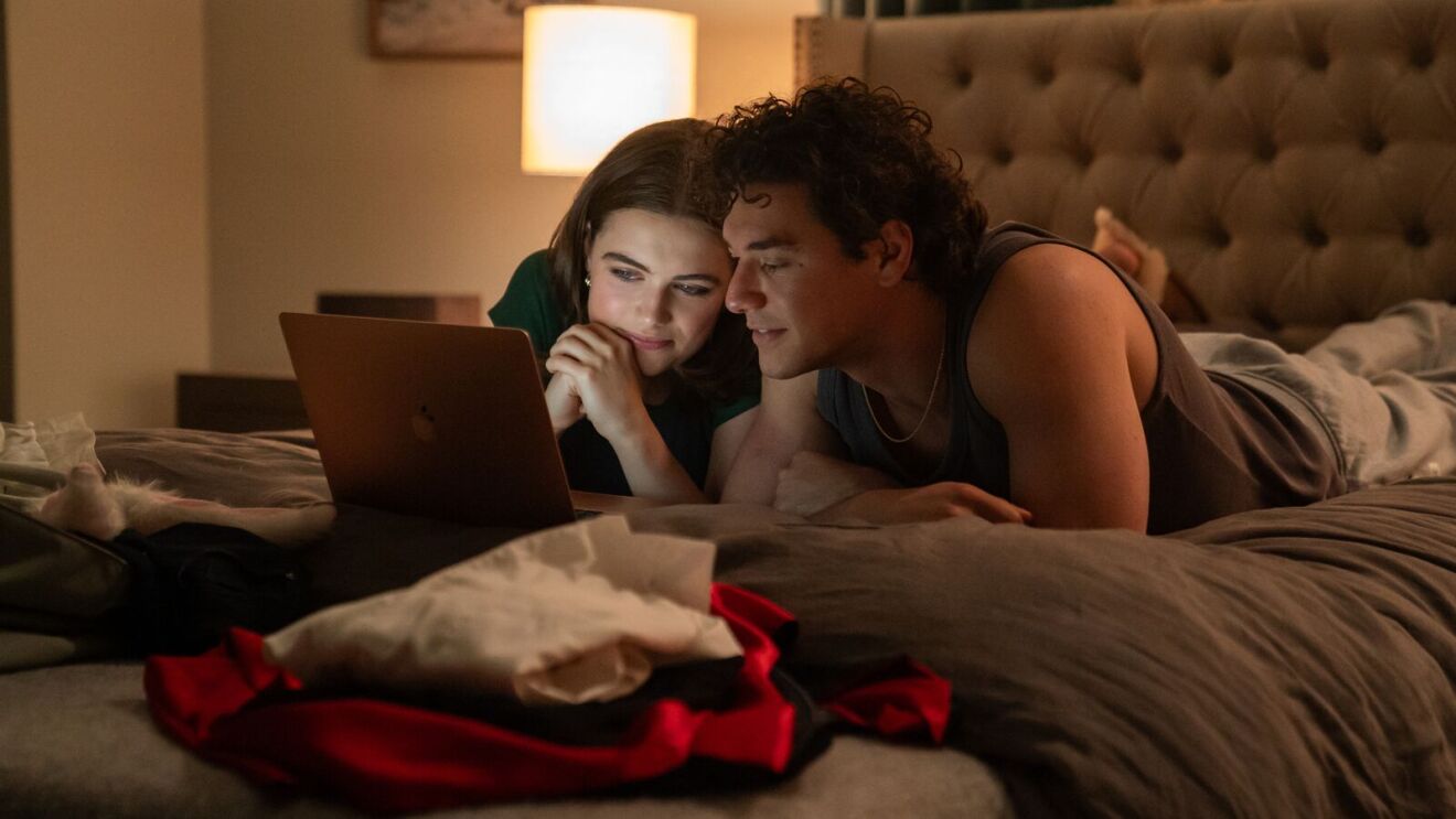 A woman and a man look at a laptop