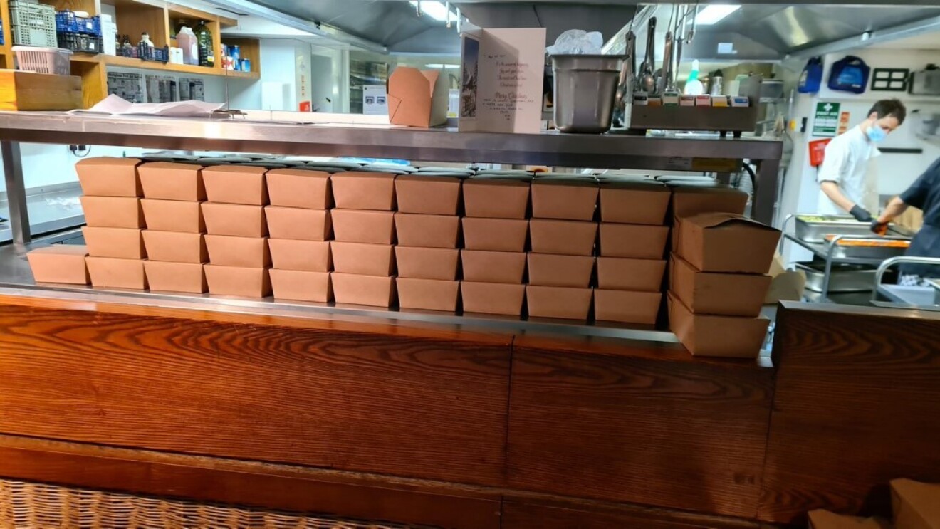 Food boxes at Waterhouse Restaurant on a counter ready for delivery.