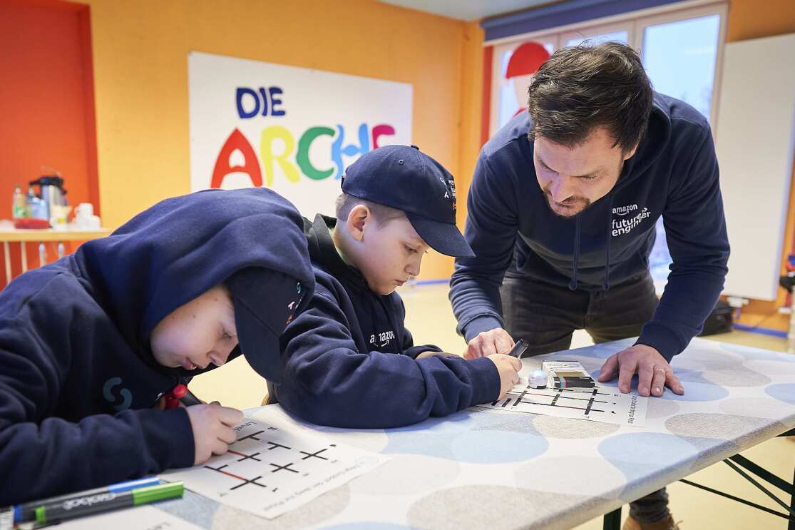 Arche Kinder mit Betreuer bei einem Coding-Workshop.