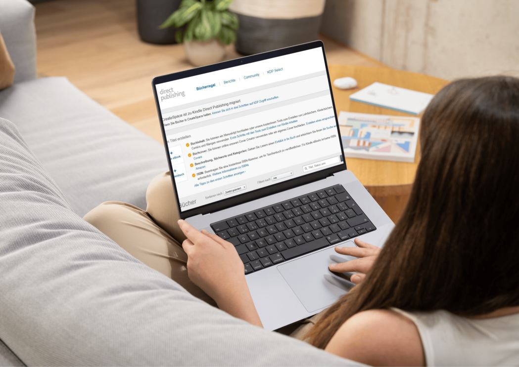 Eine Frau sitzt auf ihrem Sofa und guckt sich die Amazon KDP Seite auf ihrem Laptop an.