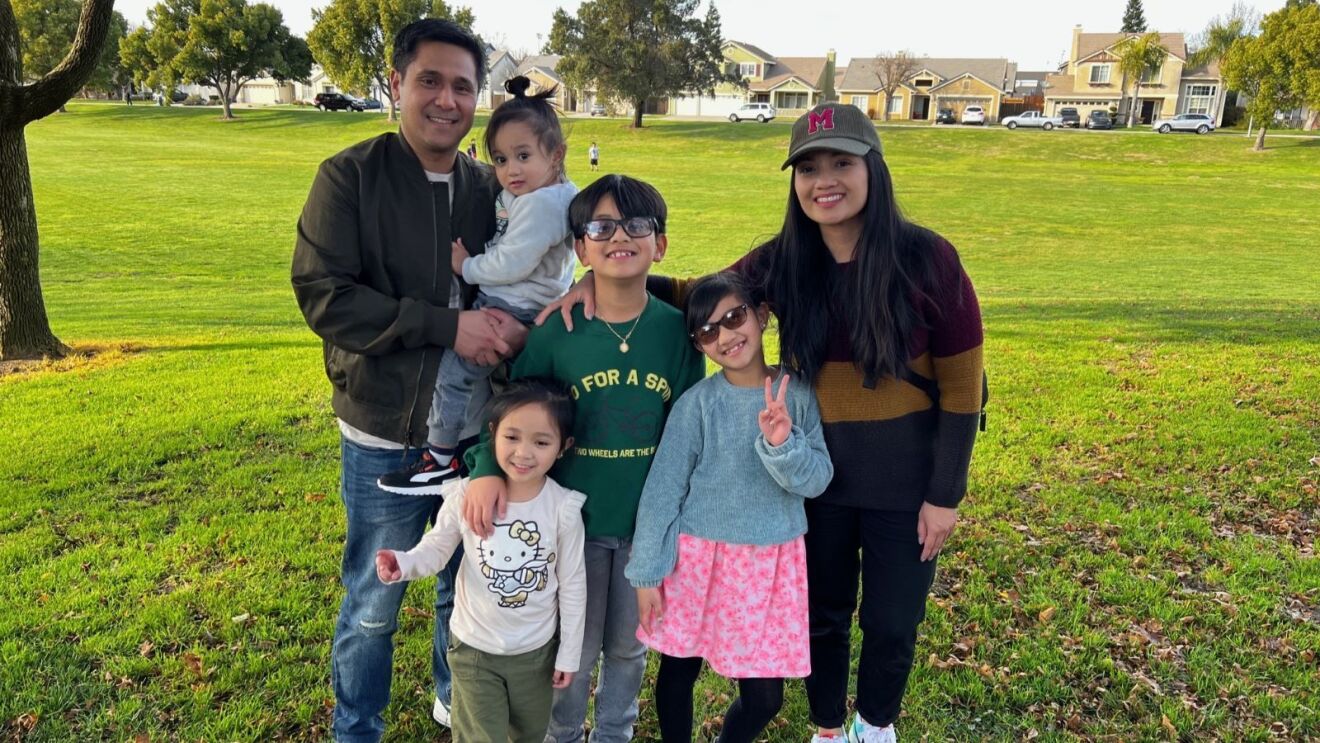 An image of Marie, a multi-site environmental manager at Amazon, with her family.