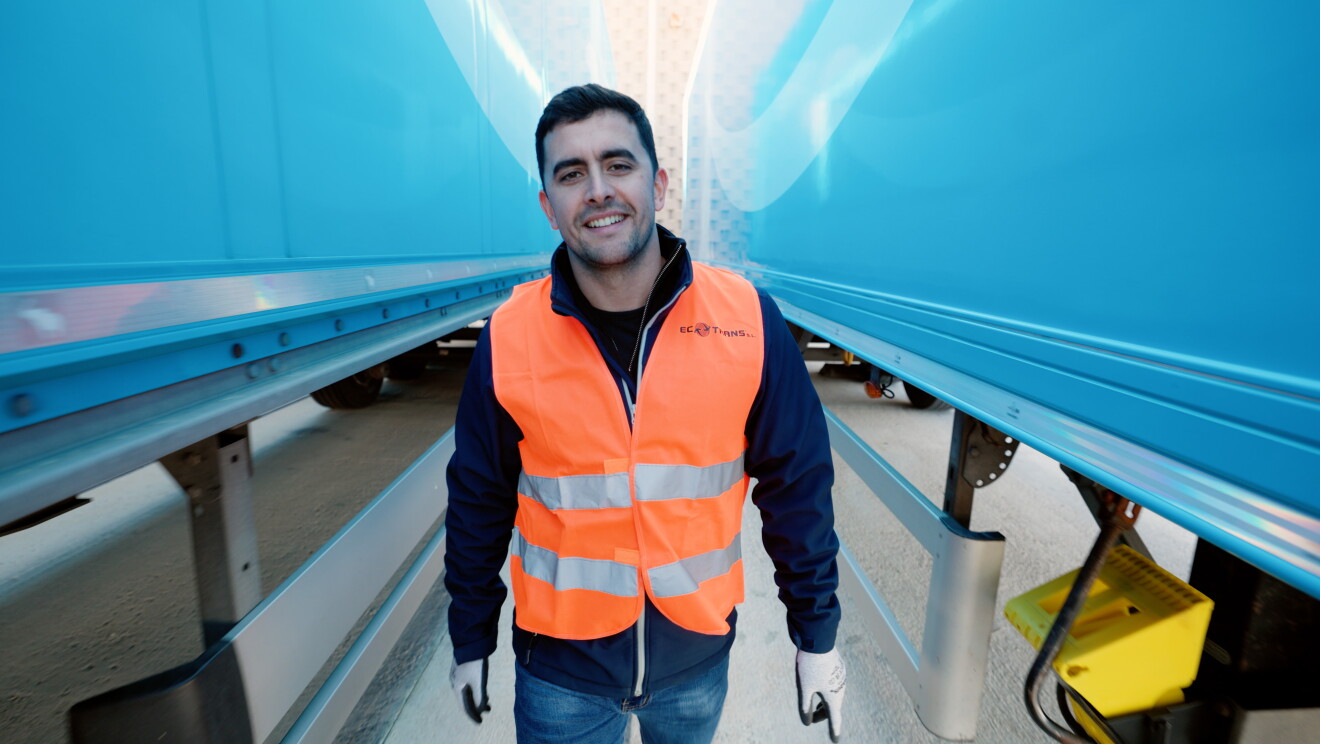 Ecotrans employee stands between electric trucks.jpg