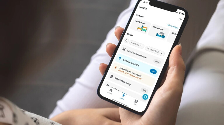 Ein Bild einer Person, die auf den Bildschirm ihres Telefons schaut das die geöffnete Alexa-App zeigt.