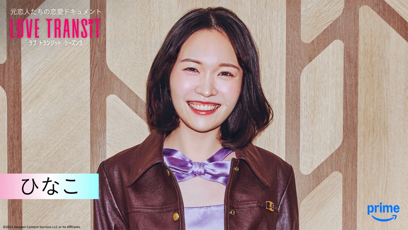 木目調の壁の前に立つ人物のバストアップ。光沢のあるワイン色のジャケット。左上隅に「LOVE TRANSIT」の文字。左下に「ひなこ」と名前が表示されている。