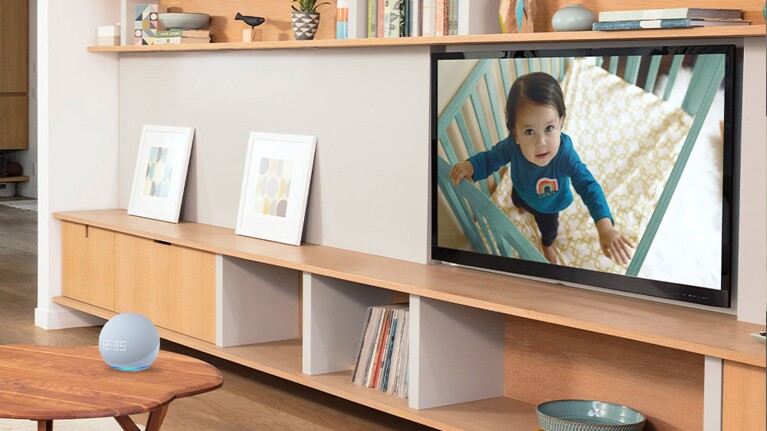 An Echo device near a TV screen showing a baby in their crib.