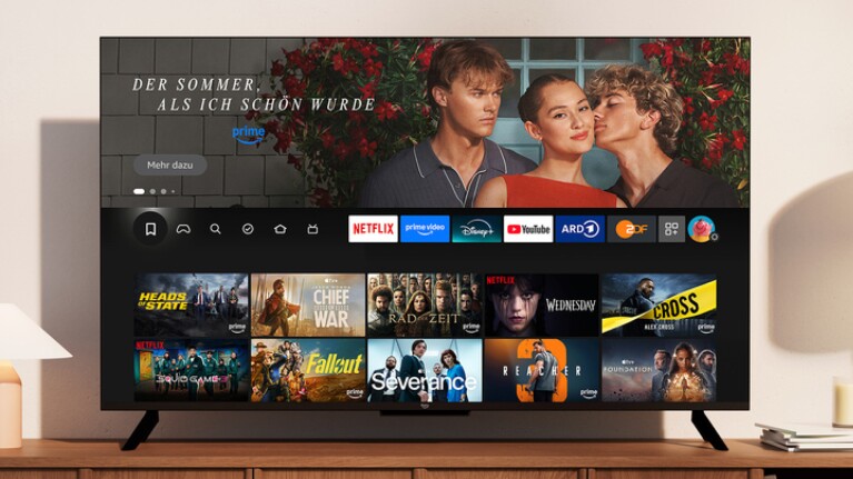 Amazon Fire TV auf einem Schreibtisch, auf dessen Bildschirm das Hauptmenü angezeigt wird