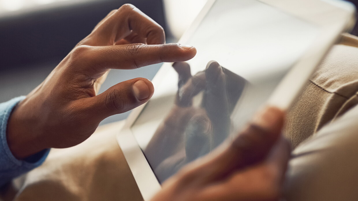 A man touches his tablet as he shops online.
