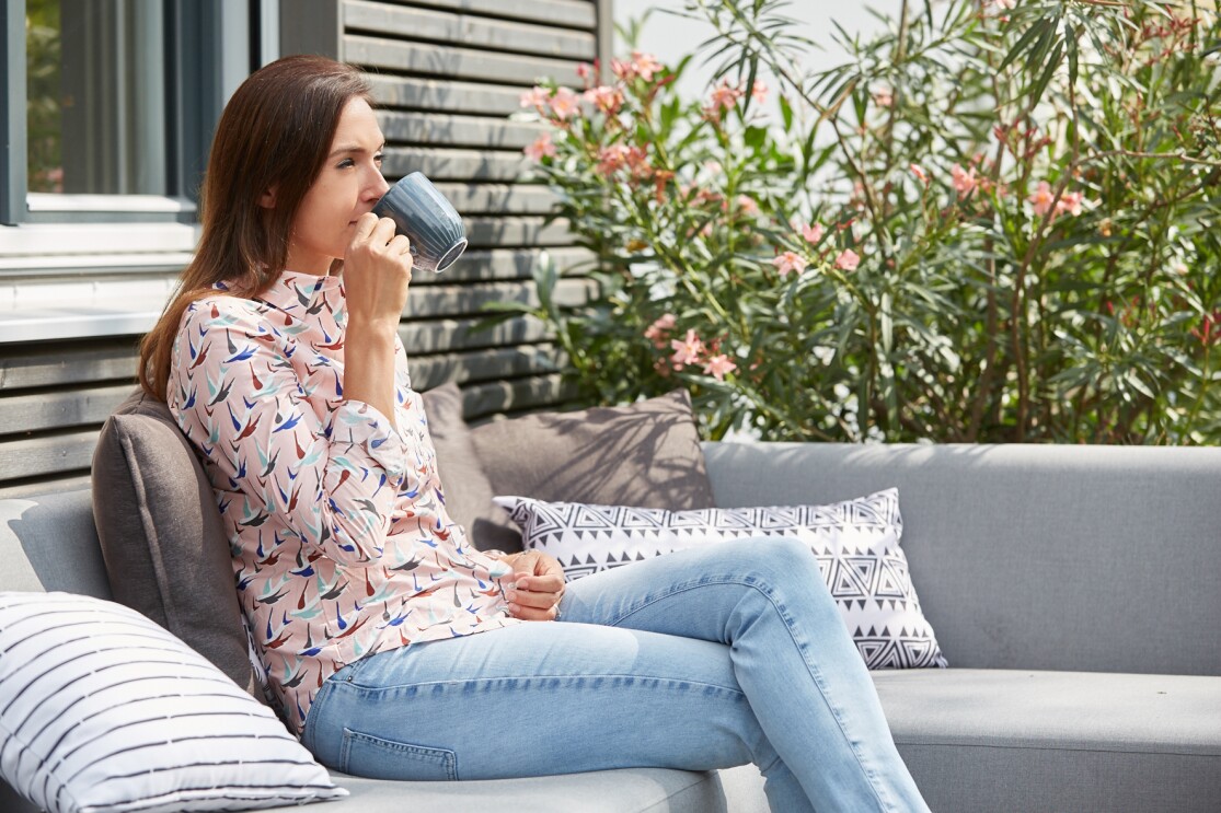Carolin Fröhlich auf der Terasse mit einer Tasse Kaffee
