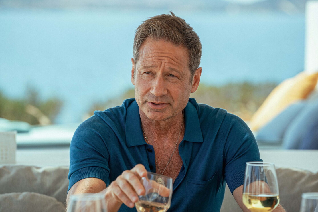 A older man holding a glass of wine