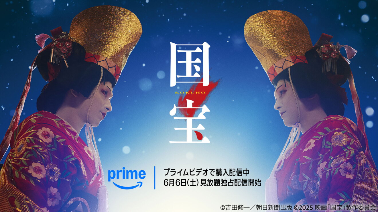ライトで照らされた中、女性の衣装を着て向かい合い、見つめ合う2人の歌舞伎役者。中央に「国宝」の文字。