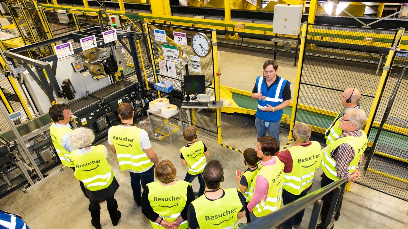 Tourguide Ulrich erklärt den Besuchern, wie die Abläufe im Logistikzentrum funktionieren.