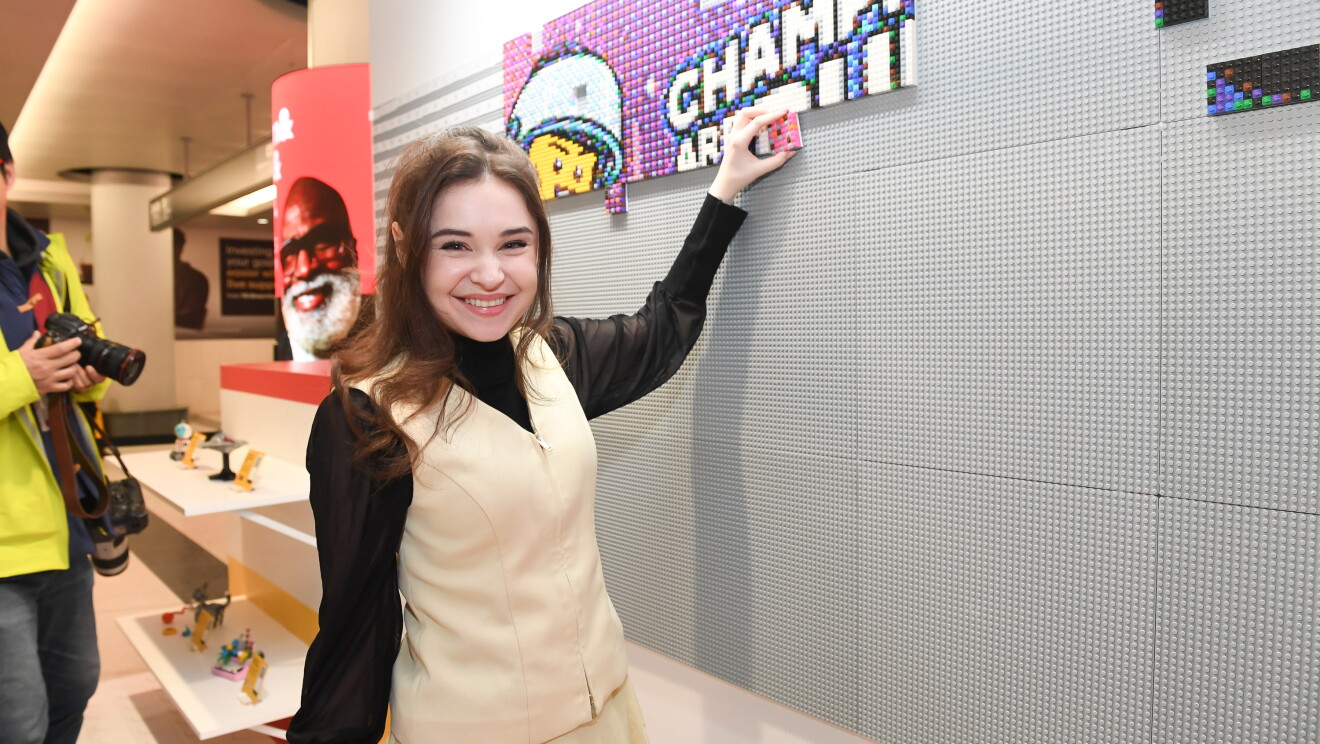 Fan putting piece on LEGO wall
