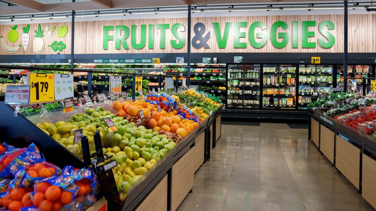 A photo of the inside of an Amazon Fresh store where there are shelves of various produce displayed. 