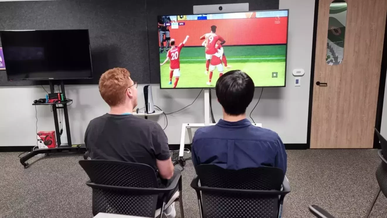 大きなモニターに向かって男性2人が参加―ゲームをしている