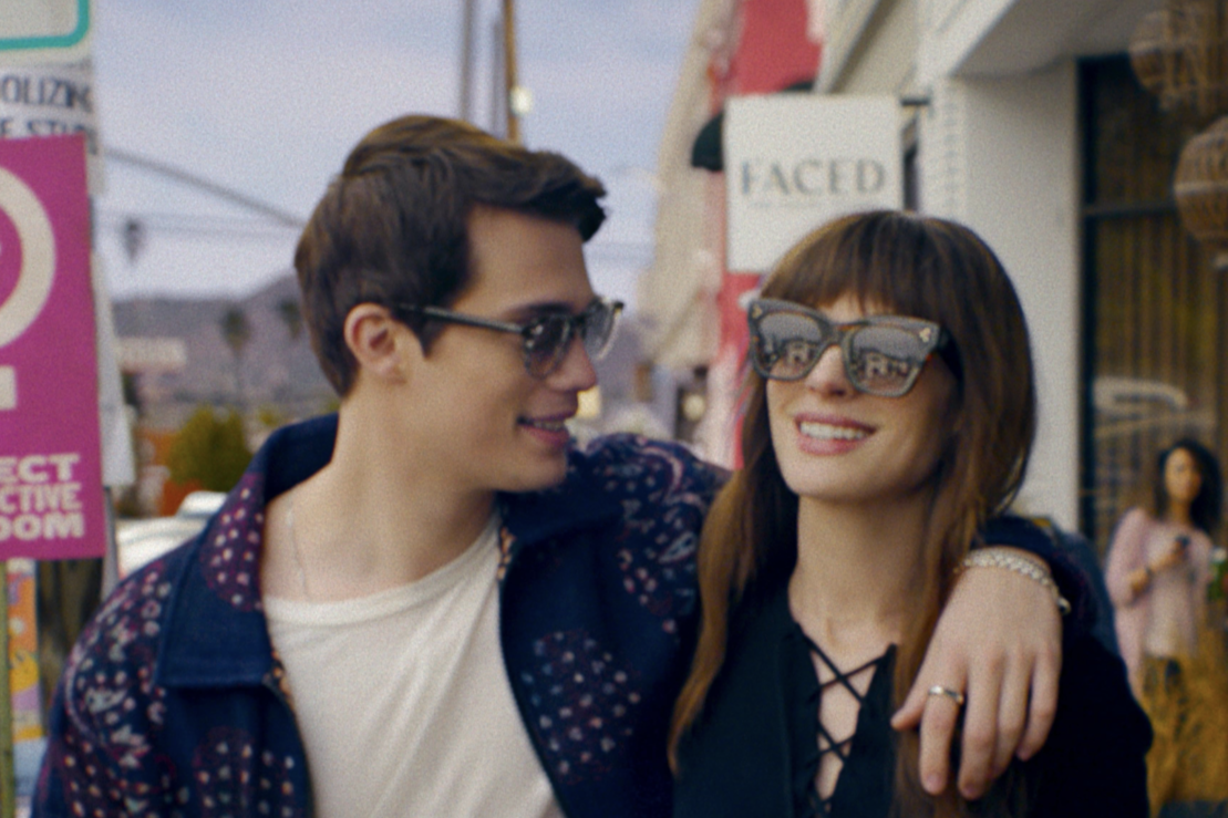 A man and woman both wearing sunglasses and hugging