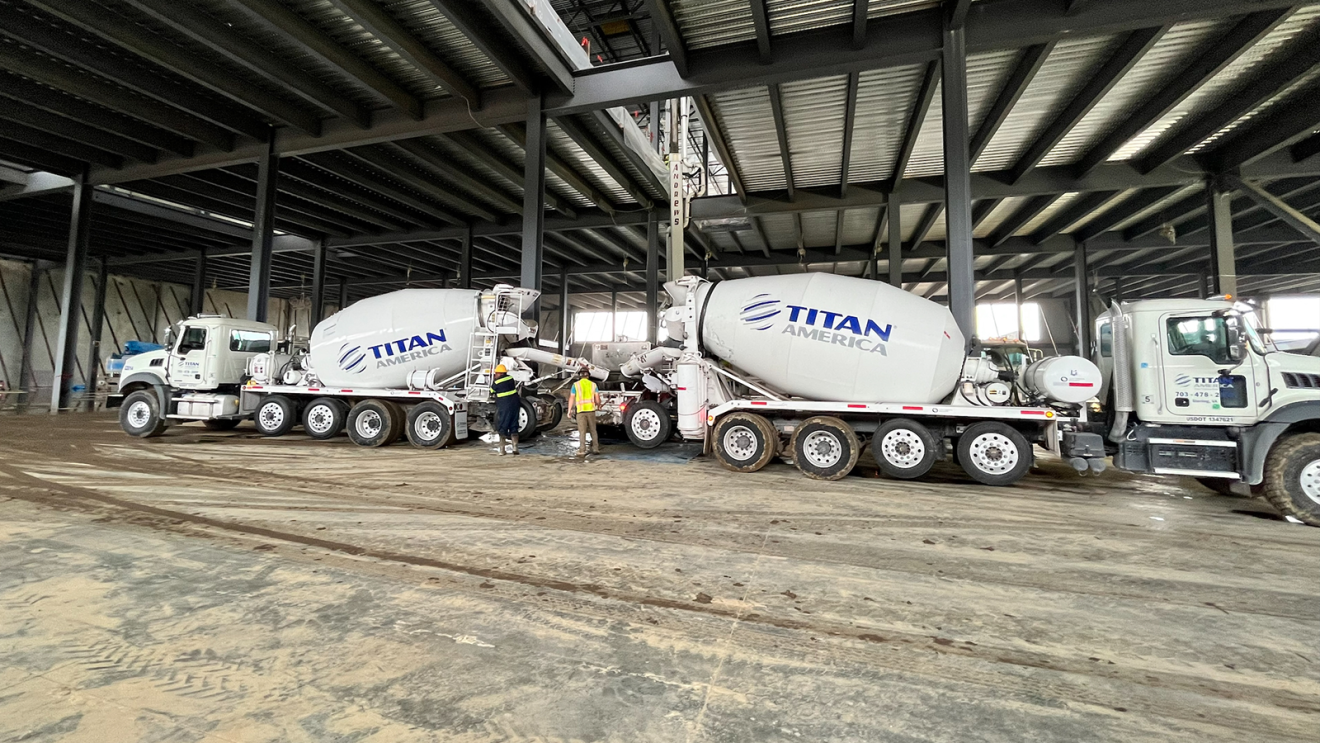 A photo of two cement trucks beneath an AWS data center.