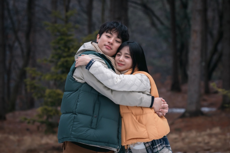 Two young Korean lovers hug in a forest