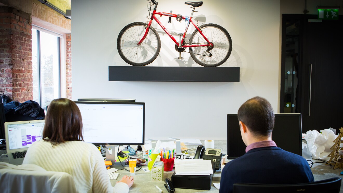 People sat at computers with a small bike in the foreground