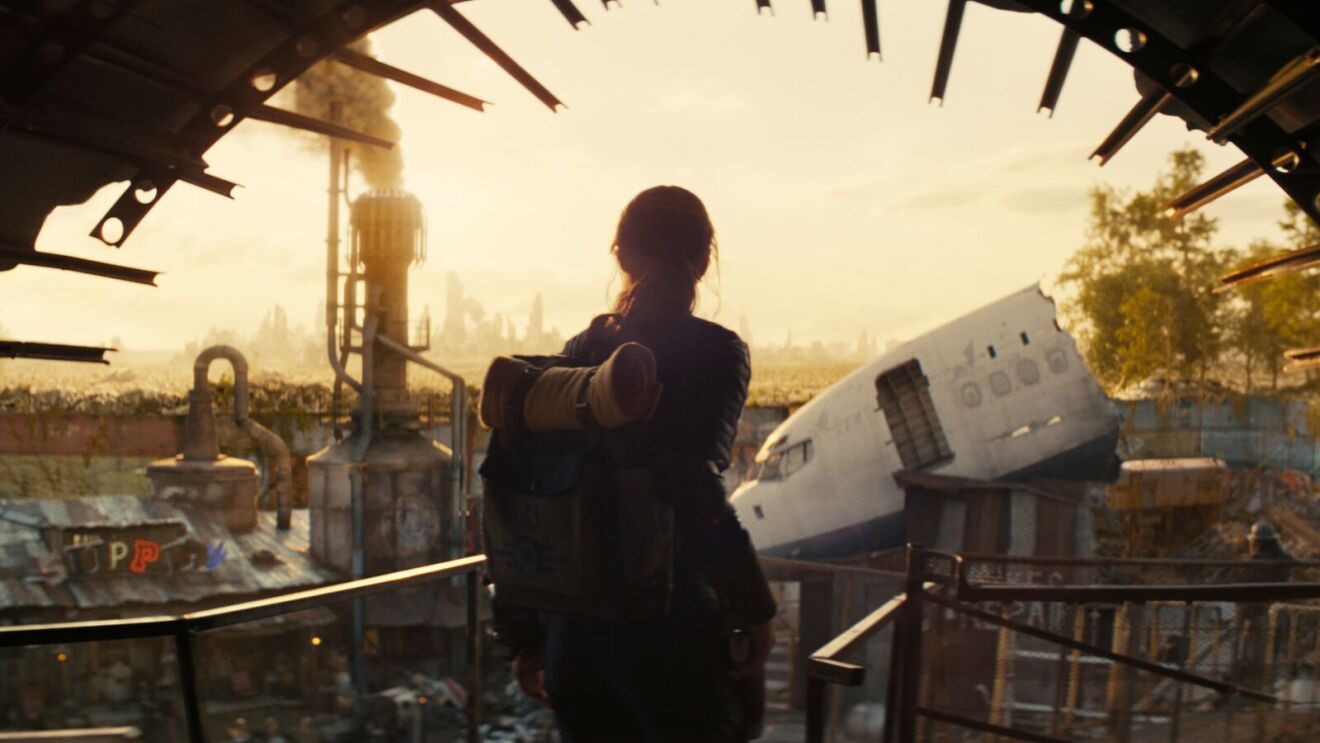 Fallout: Silhouette gazes at dystopian cityscape from scrapyard platform