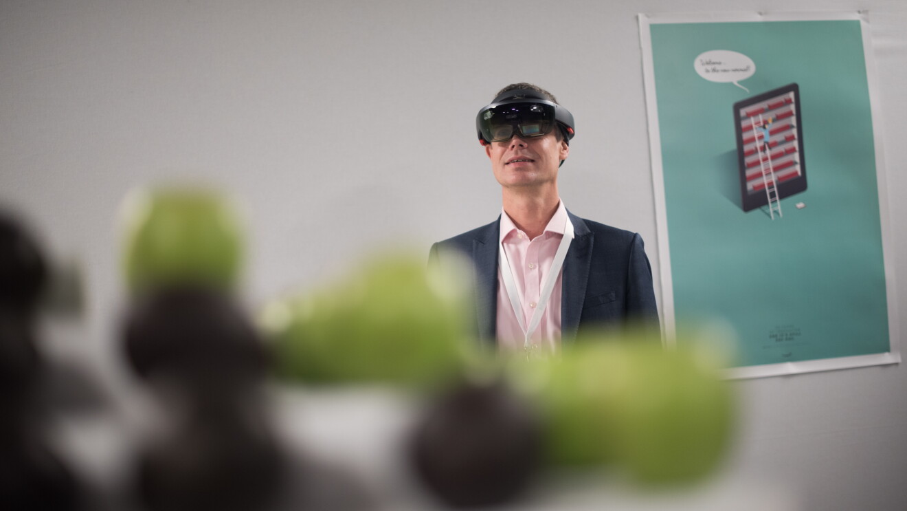 Ein Amazon Mitarbeiter testen eine VR Brille, mit der der Reifegrad von Obst und Gemüse ermittelt werden kann.