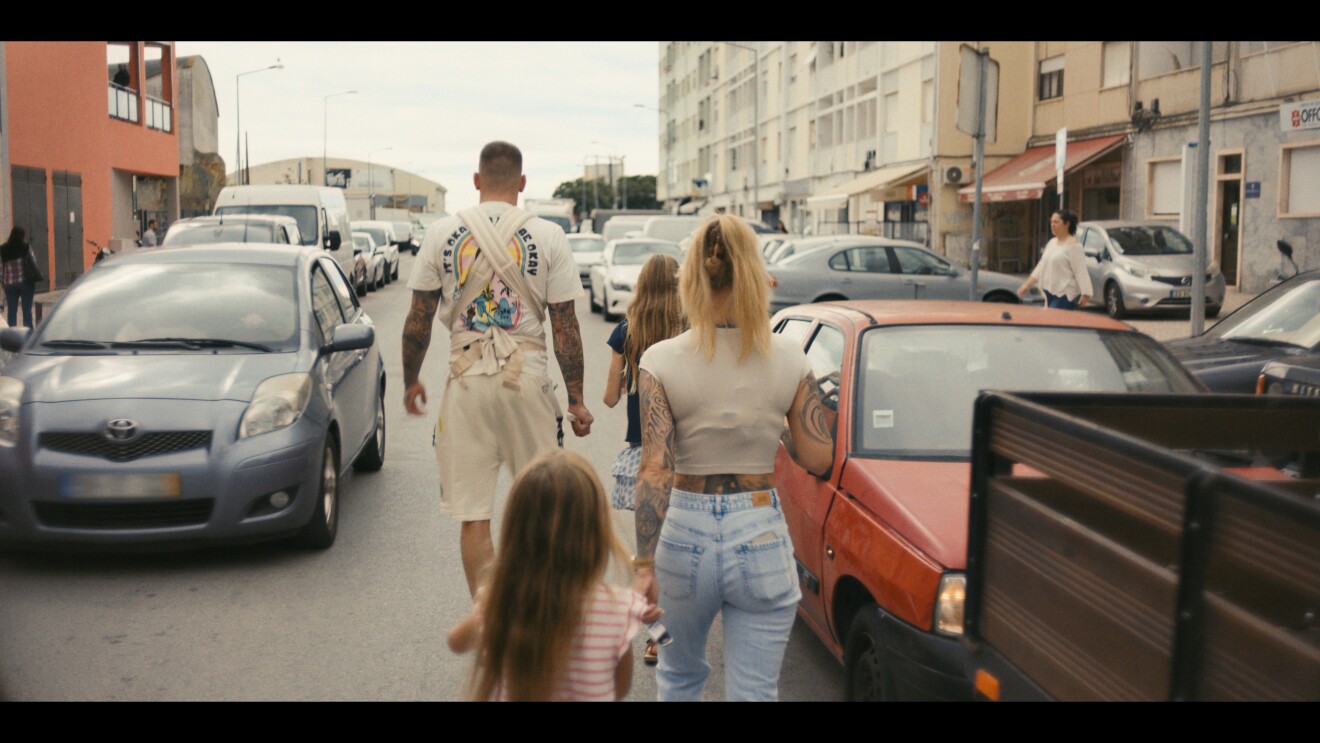 GZUZ – Licht & Schatten: GZUZ läuft mit seiner Frau und Kindern durch eine Straße, umgeben von Autos.