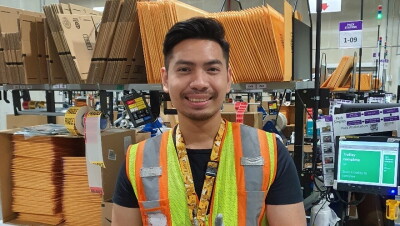 Aung Kaing giving a thumbs up in the fulfillment centre in Singapore