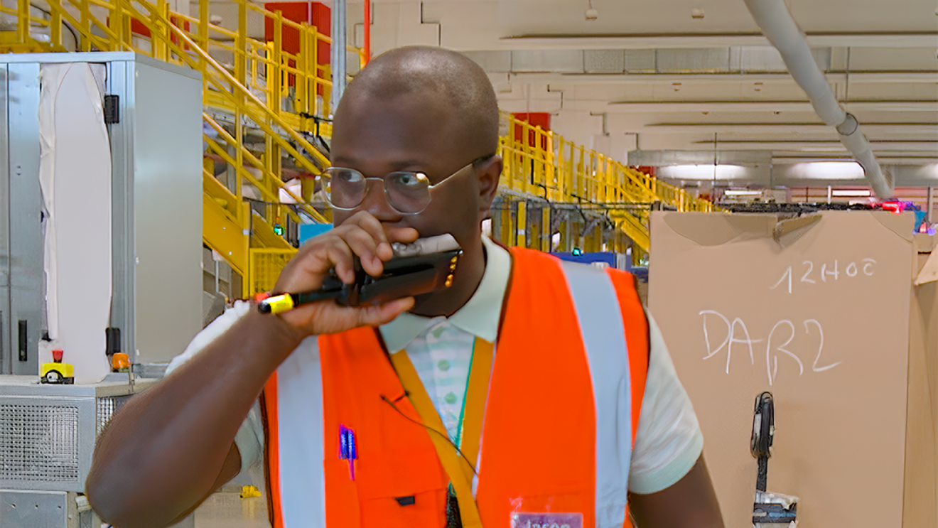 Travailleur dans un centre de distribution parlant dans un talkie-walkie