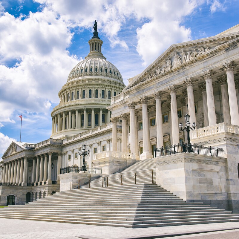 The U.S. Capitol, shown with no people in the image, in front of a blue sky with some visible clouds