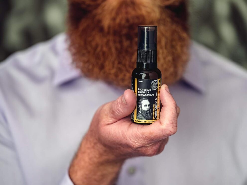 A man holding a bottle of Professor Fuzzworthy product, available on Amazon Australia.