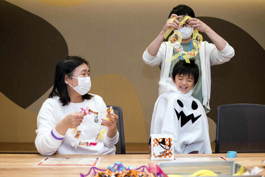 出来上がったキャンディレイを首にかける子どもと保護者の方