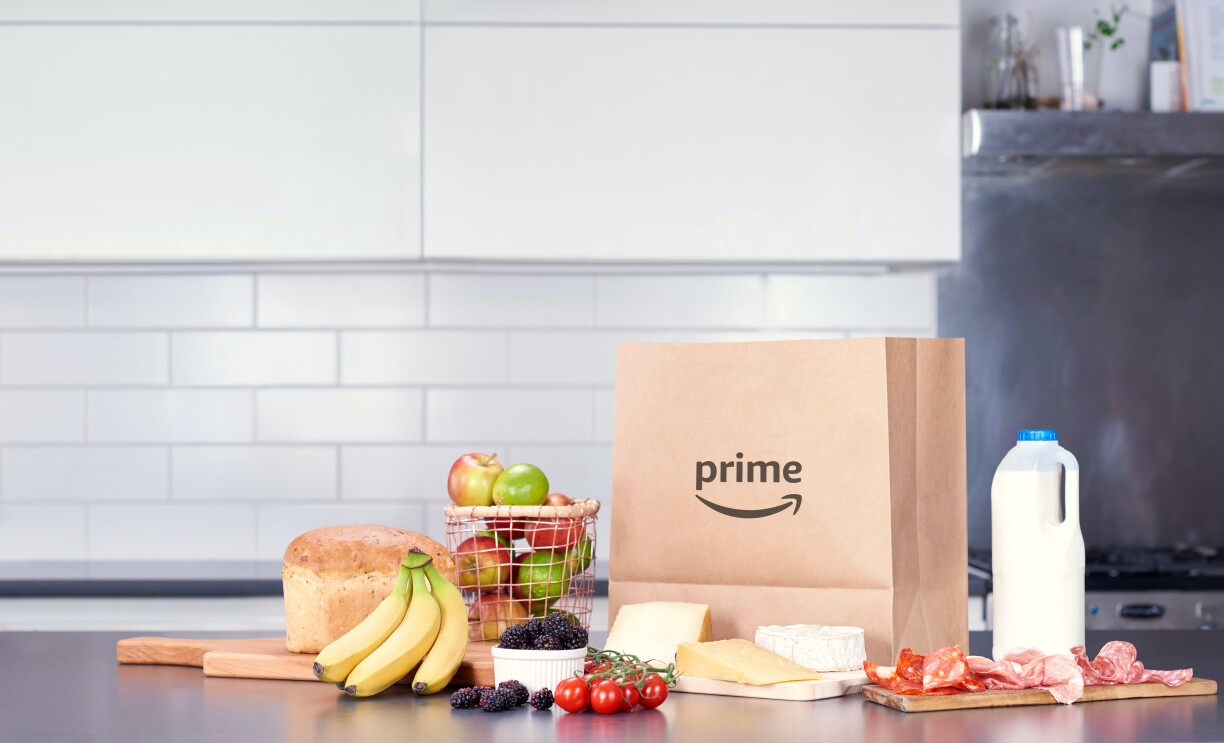 Paper bag with prime logo, milk carton and basket of fruit 