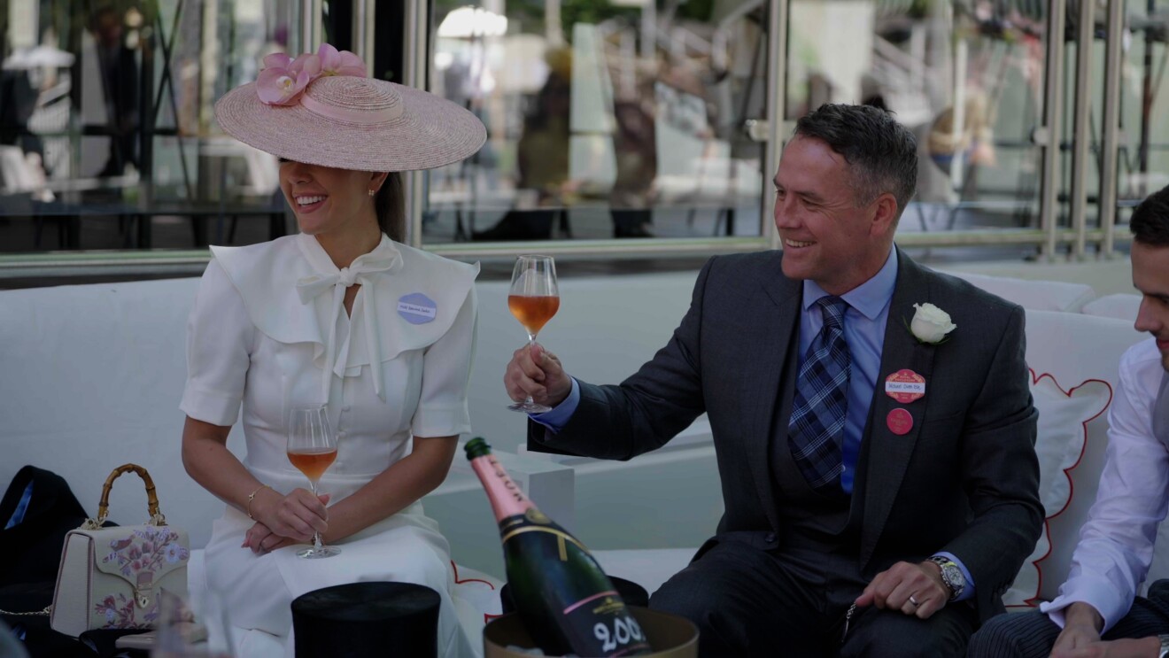 Michael Owen raises a glass at the races, sitting next to daughter Gemma