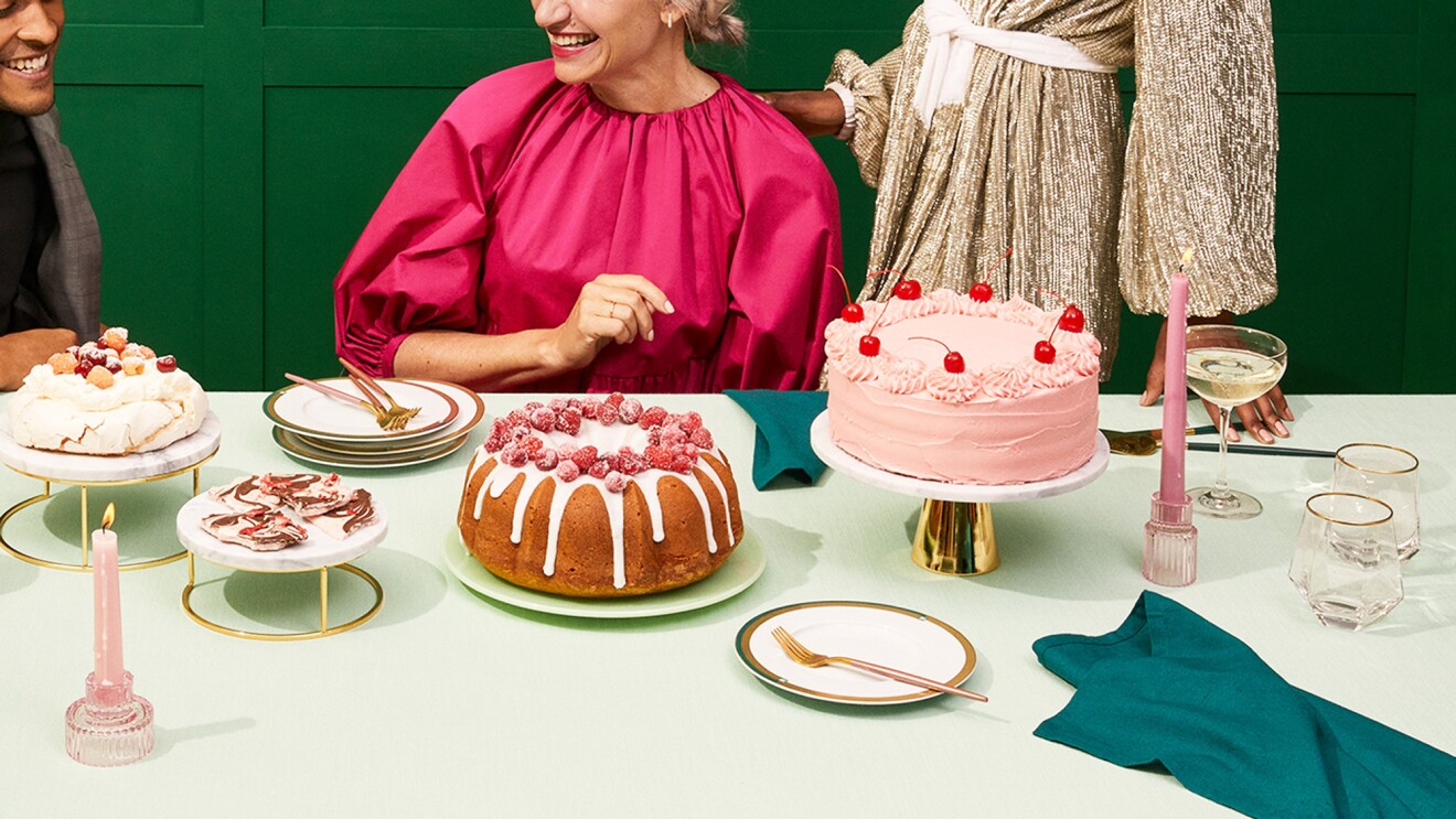 人们围着一张桌子吃东西。