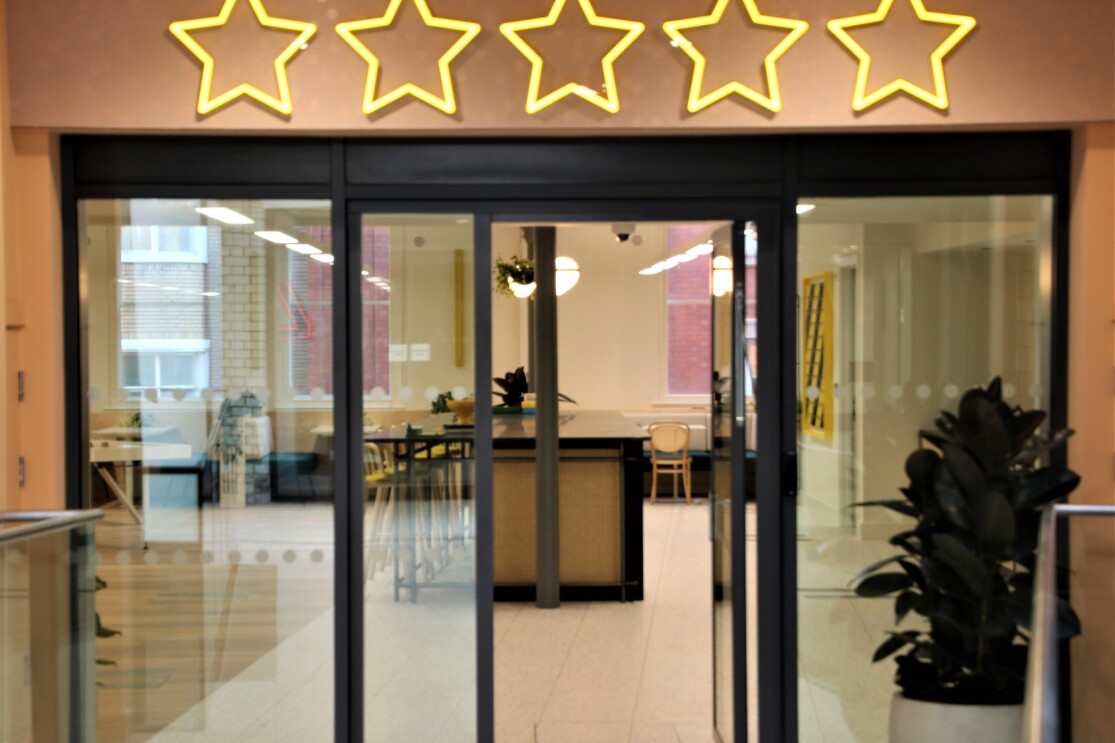 Contemporary workspace entrance featuring stylish star-shaped lighting fixtures in Amazon's Manchester office