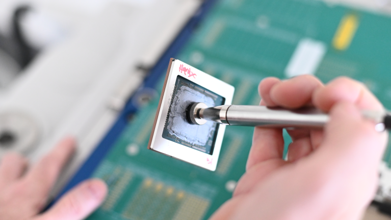 Close-up of microchip repair with precision tool