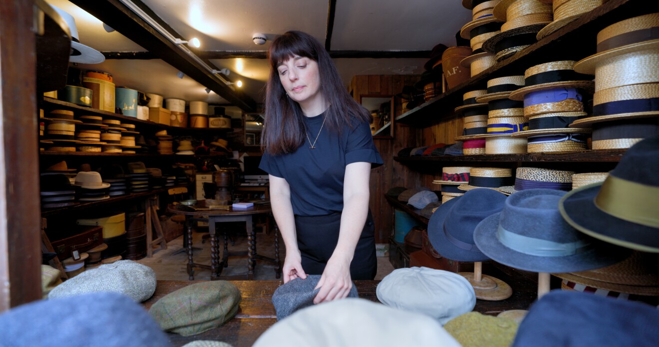 A lady is sorting out traditional British hats to be sold to European Customers.