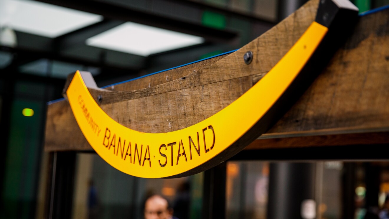 木制结构上有一个黄色的香蕉形状的标志,上面写着“香蕉摊”。