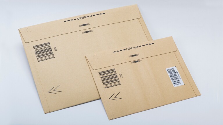 茶色い封筒。少し厚みがあり、開ける場所を示すOPENの文字が印刷されている