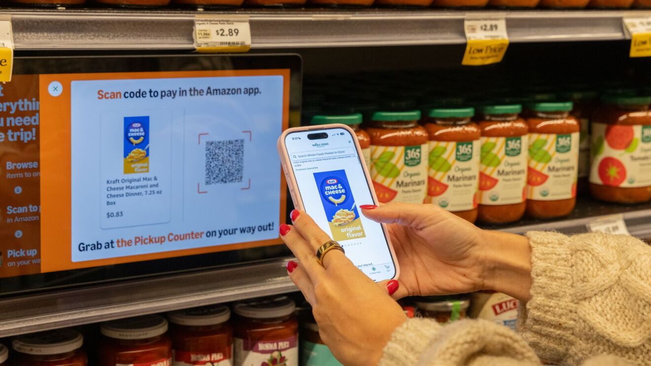 Shopper scanning QR code on Amazon app in grocery store aisle