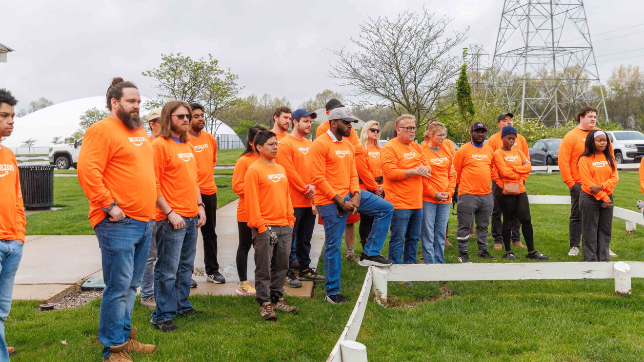 Group in bright orange shirts gathered outdoors for community event