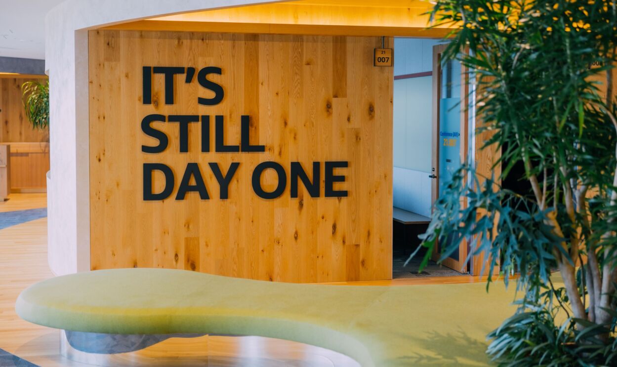 IT‘S STILL DAY ONEの文字。手前にグリーンのソファと植物が見える