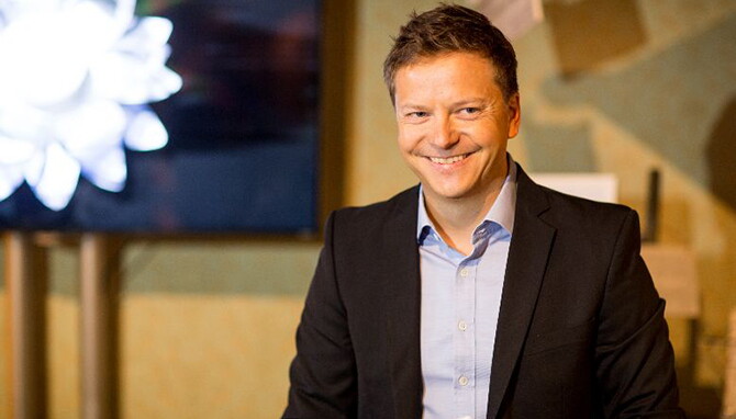 Markus Schöberl, Director Seller Services bei Amazon, lächelt und schaut seitlich auf jemanden neben der Kamera. 